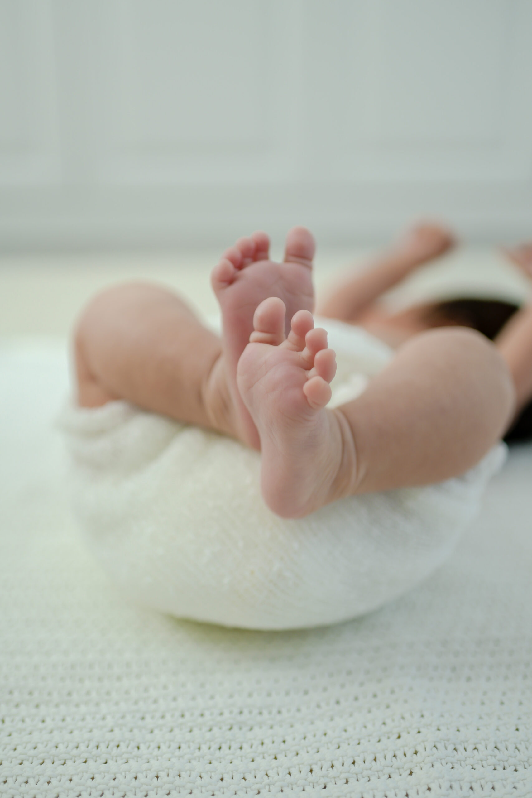 Close shot of baby's feet laying on a blanket